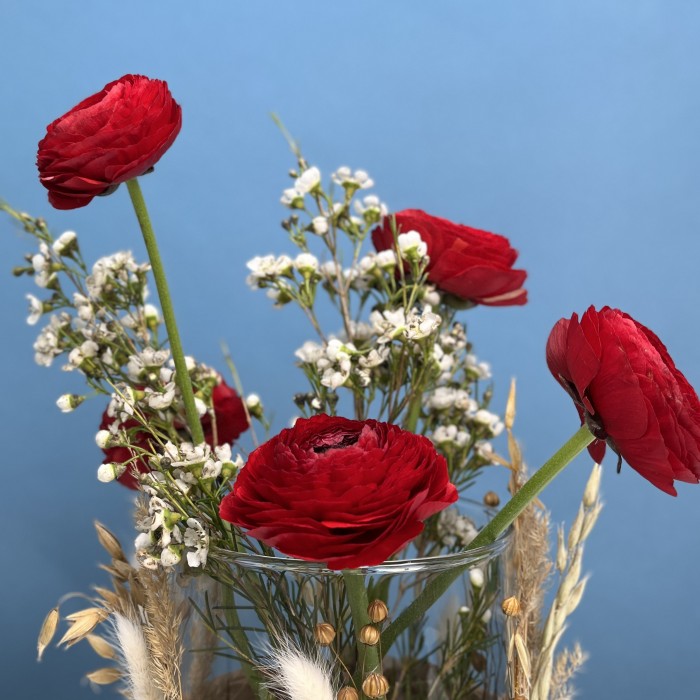 Настольная композиция на ресепшен с красными ранункулюсами